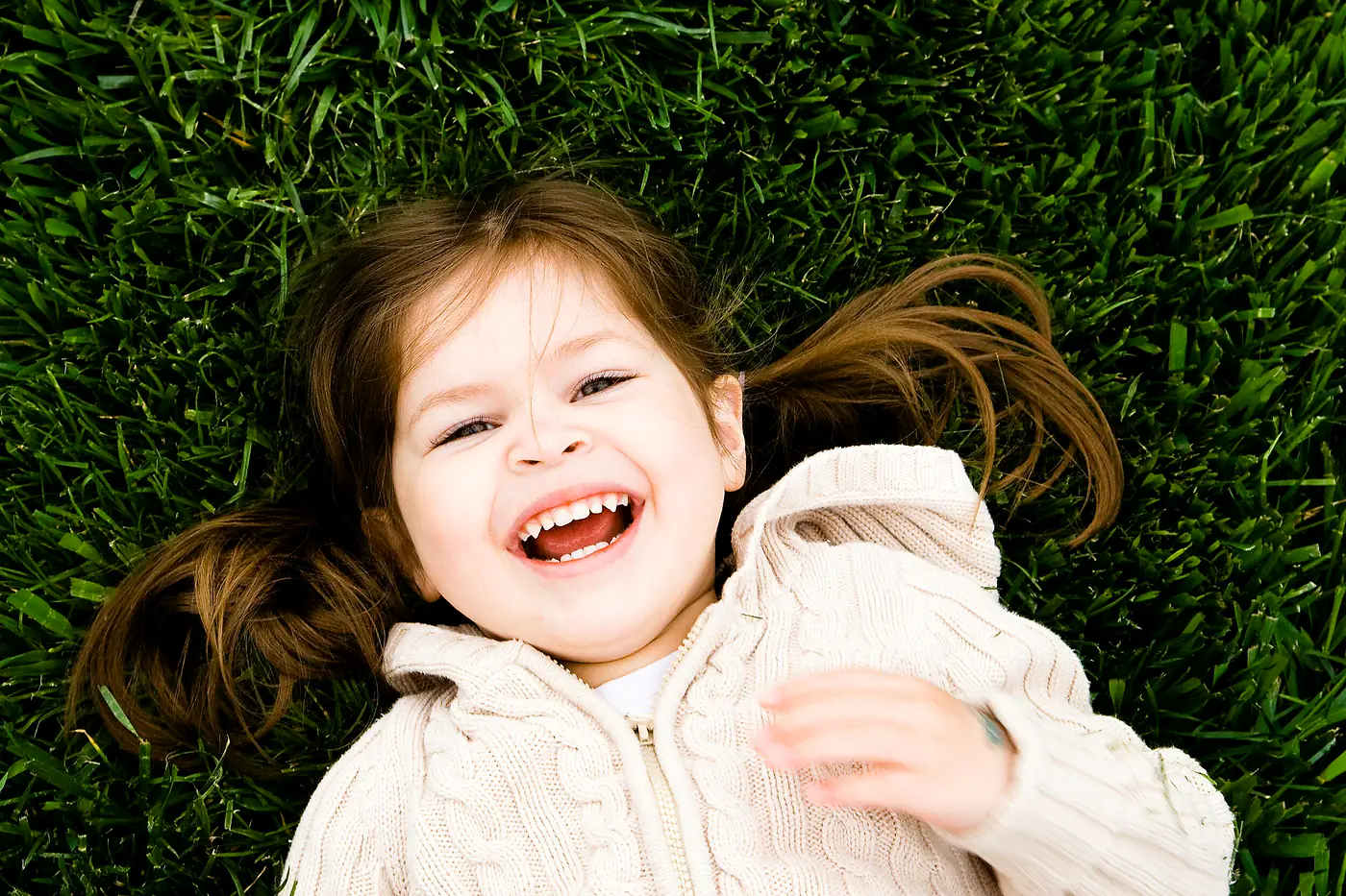 Little girl laughing in the grass